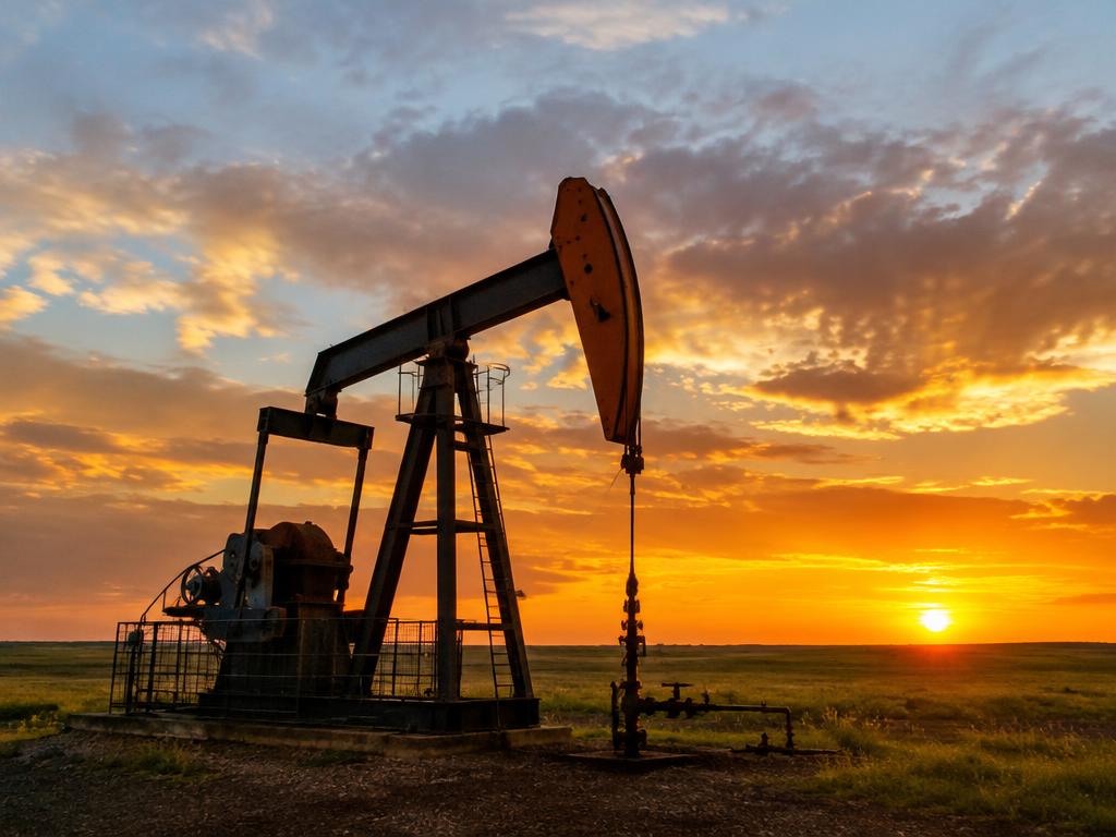 An oil pumpjack extracting petroleum at sunset